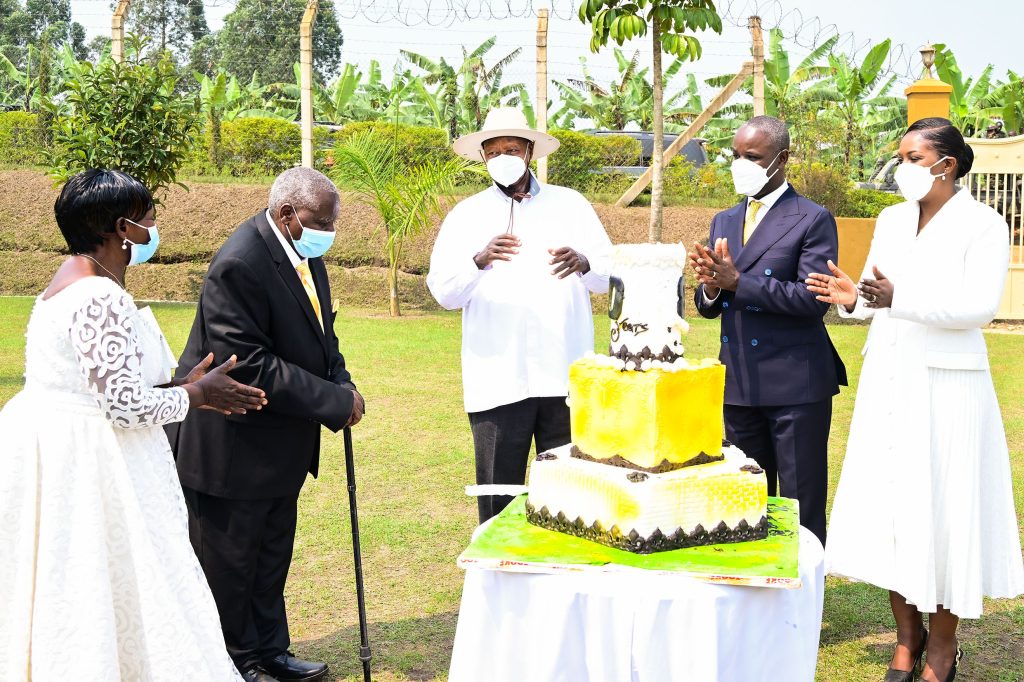 President Museveni (C) and Deputy Speaker Thomas Tayebwa join Mzee Daudi Bangirana and his wife (L) to cut the cake as they celebrate Bangirana_s 80ths birhday in Ruhinda on Friday. PPU Photocake5