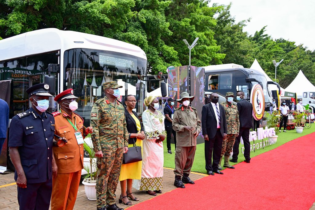 President Museveni (C) with Chief Justice and senior security officers pose for a photo infront of some of the buses made in Uganda aa he toured an exhibition during the 1st Kampala Defence and Security