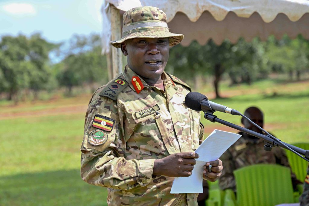 The Chief Guest Chief Of Staff Special Force Command Brig. Gen. Paul Namawa (right) hands over a gift to the Best Overall Trainee PPC Bagonza Nuuh (left) during the Passing out of PPG Trainees at the Police Presidential Guard  Special Force Training School Fort Samora Machel in Kaweweta on the 22nd October 2024. Photo by PPU/Tony Rujuta.