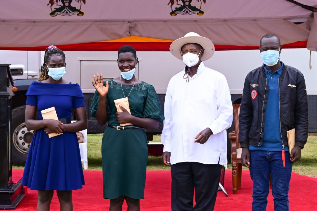 President Museveni poses for a photo with three of the graduates of the skilling programme at the Teso industrial hub shortly after commissioning the facility on Tuesday He gave them a financial support