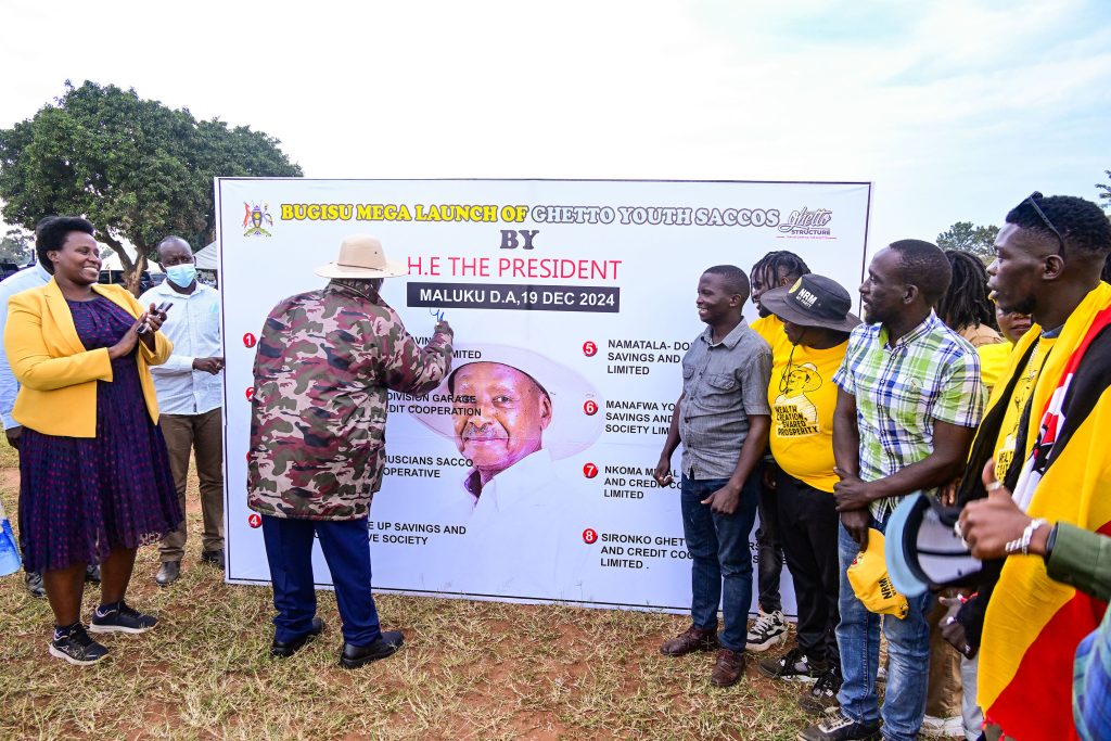 President Museveni launches the Mbale Ghetto youths SACCO as State House Comptroller Jane Barekye L looks on Standing R are some of the Ghetto youths members PPU Photo