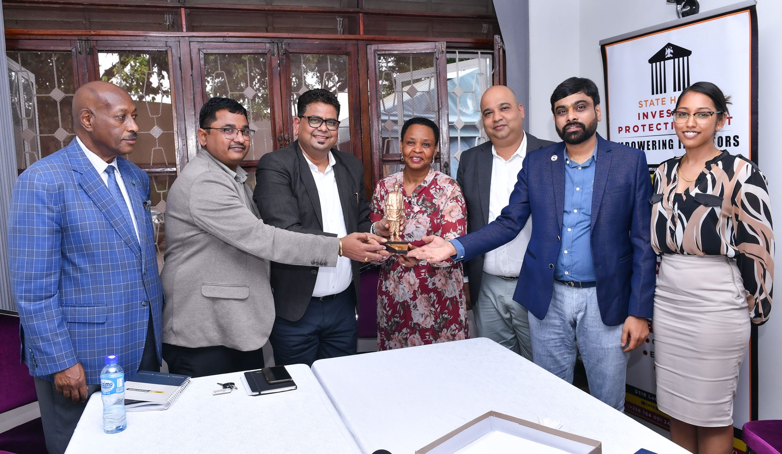 Col Edith Nakalema C head of State House Investors Protection Unit receives a statue of unity from a delegation of the Indian Business Forum led by their director genral Rajesh Kumar 3rd L as Hon Fred Ruhindi looks on.