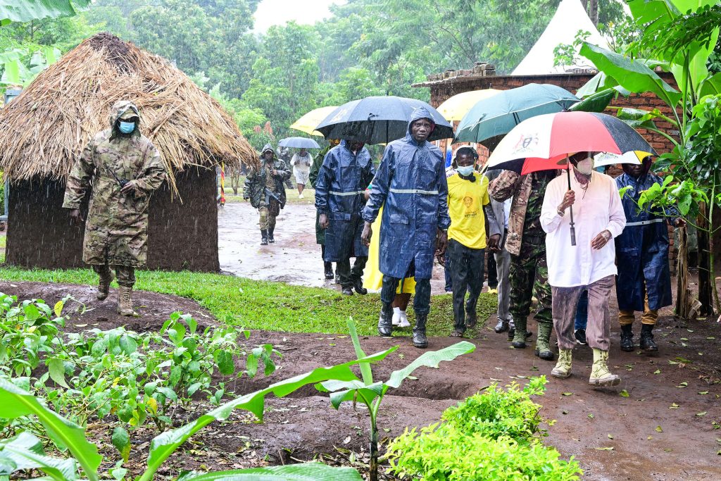 President Museveni arrives at PDM beneficiary farmer Eliot Mukasas passion fruit garden in Nawampiti Luuka district amidist a heavy downpour on Wednesday Dresses in yellow is Eliot Mukasa PPU Photo