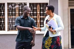 Head of State House Investors Protection Unit Col Edith Nakalema shares a light moment with Makerere University Guild president Vincent Lubega Nsamba at her offices in Nakasero on Friday PPU Photo