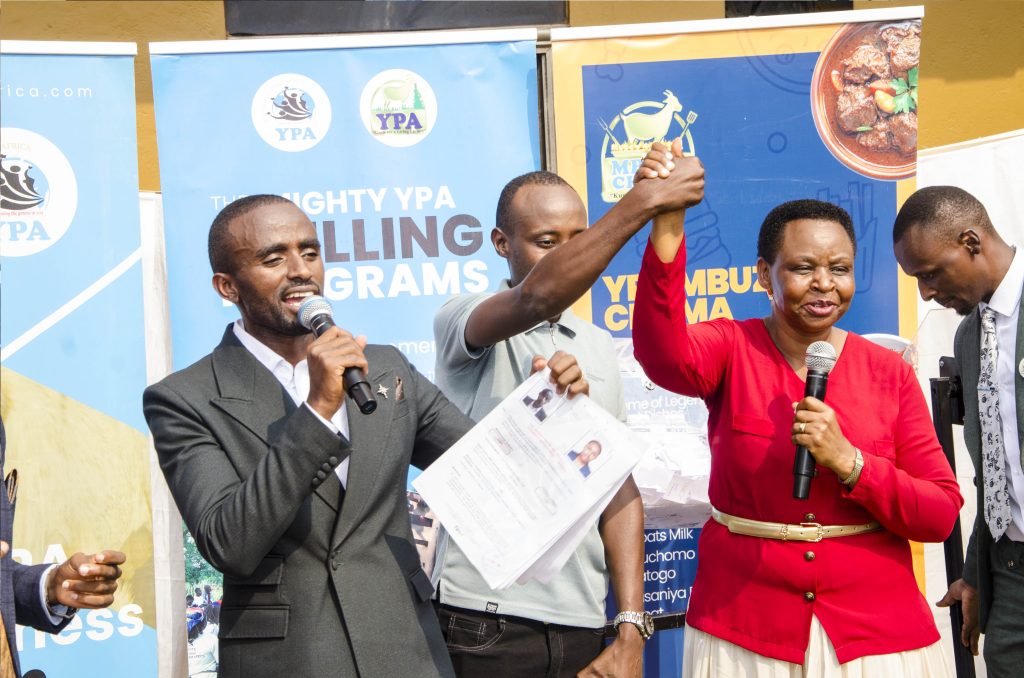 Col. Edith Nakalema, Head of State House Investors Protection Unit (Second Right) announcing the winner of the brand new Toyota Harrier Lauben Ndahura (Centre). PPU PHOTO.